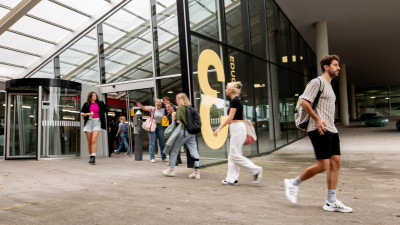 Studenten lopen gebouw in en uit