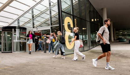 Studenten lopen gebouw in en uit