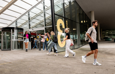 Studenten lopen gebouw in en uit